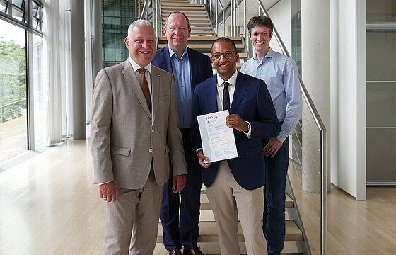 Group photo with four people in the Faculty of Economics, award ceremony for the 2024 doctoral prize from Kreissparkasse Gelsenkirchen