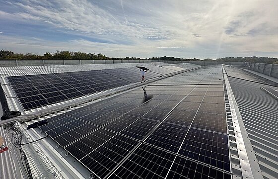 Photovoltaikmodule auf dem Dach des Parkhauses P1, dazwischen läuft eine Person entlang